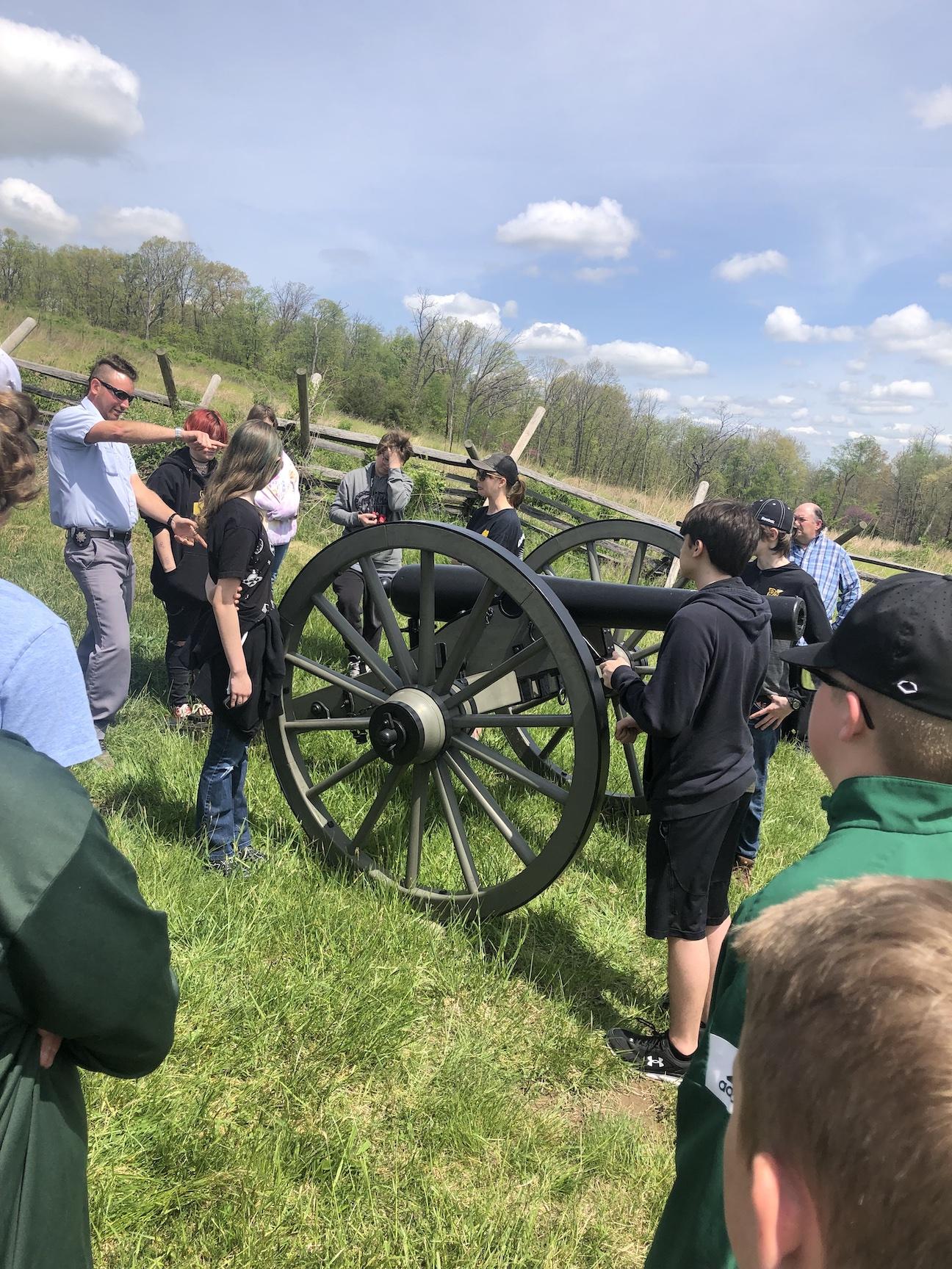 A Gettysburg tour guide instructs students on the act of reloading a piece of field artillery as they learn about the action on Seminary Ridge, Cemetery Hill, and Culp's Hill