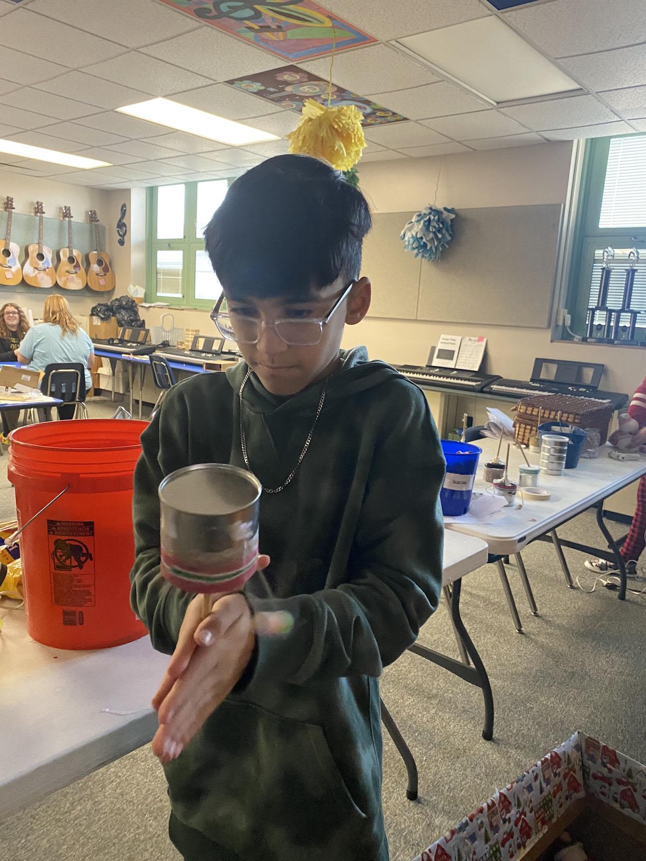 Sixth Grade Student, Mason Wyke, tries out his completed hand drum