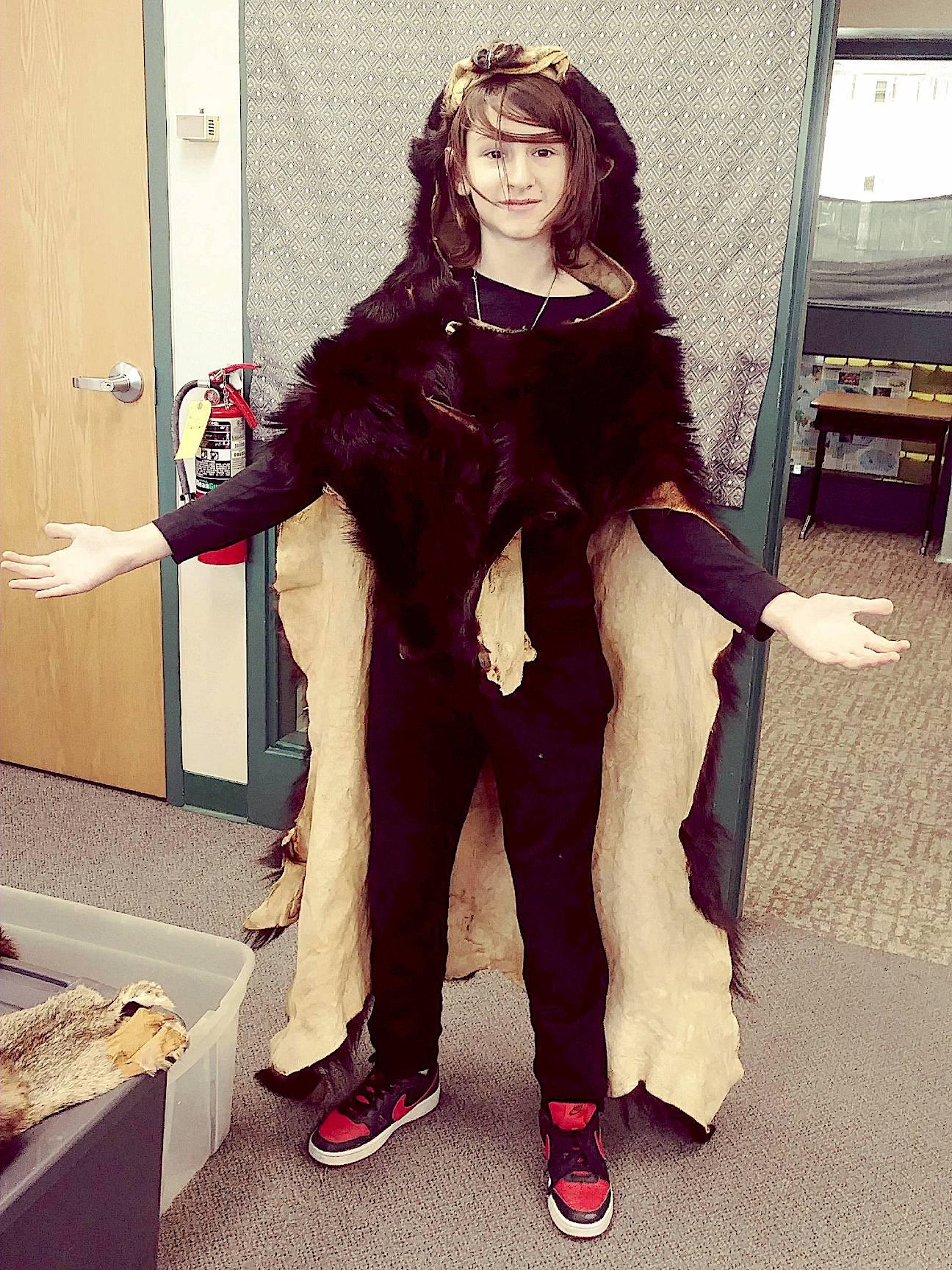 Eighth grader, Ben Owens, models the bear skin Ghost shared during his presentation