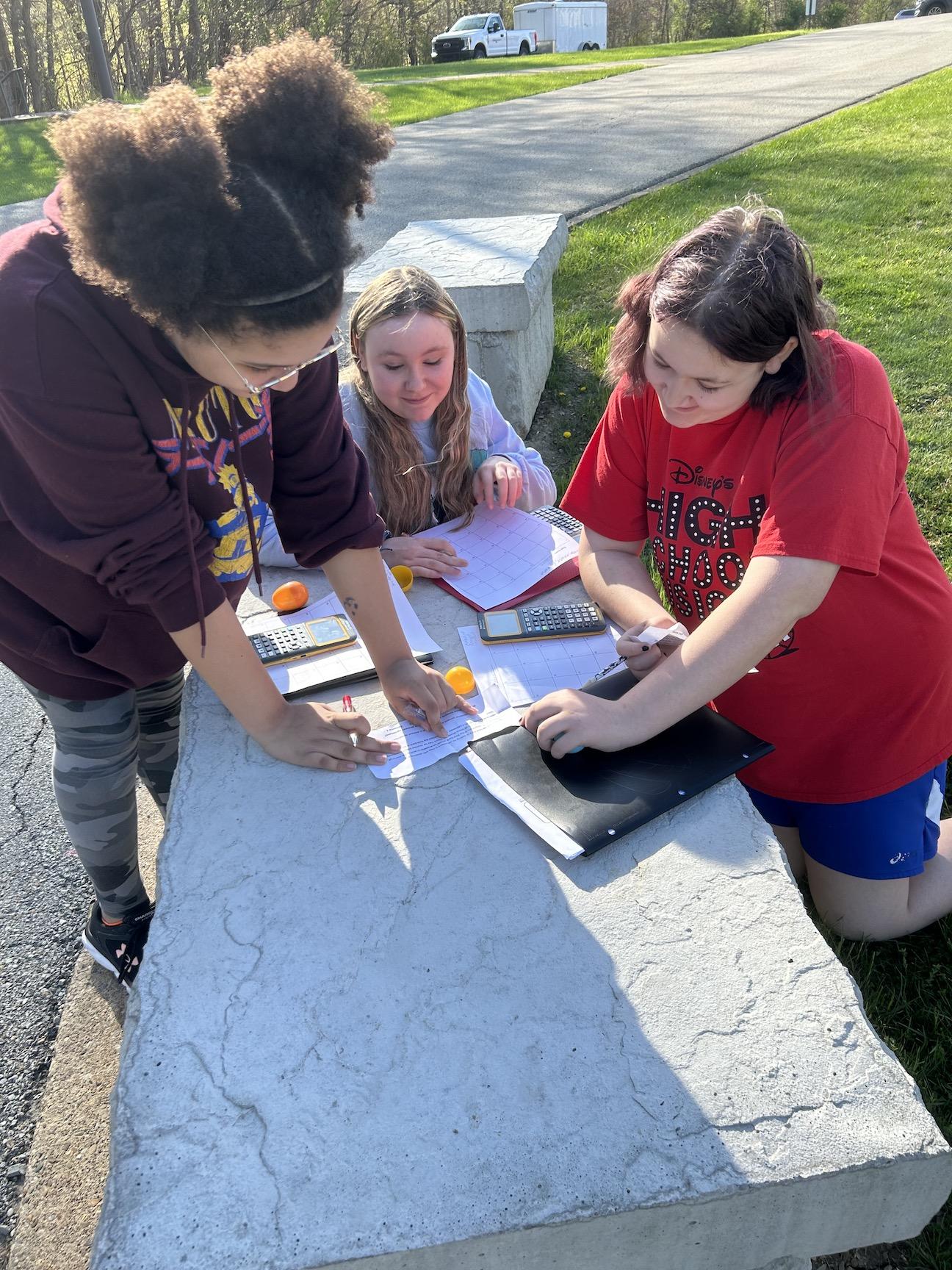 Carmella Dubbs, Katelyn Funk, and Melodie Funk work together to solve a math problem